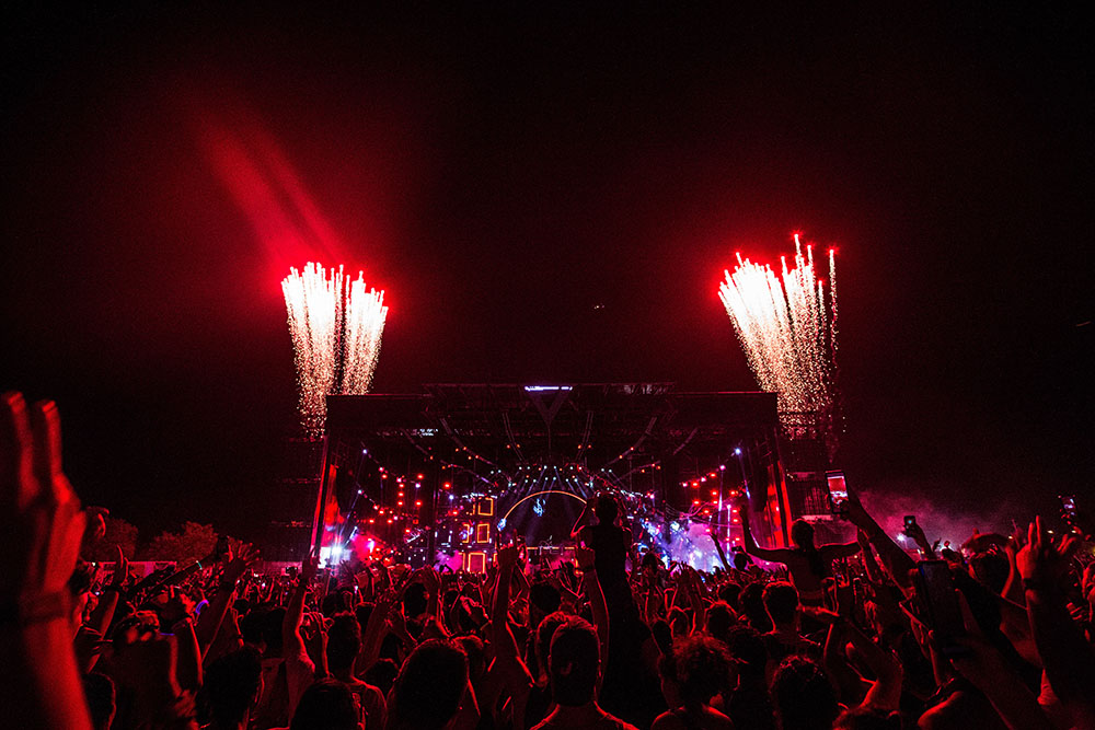 Temporary Event WiFi Tips Concert crowd at night facing the stage with a reddish lights and fireworks on either side