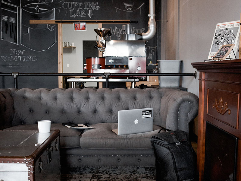 Best Chicago Coffee Houses Free WiFi Coffeehouse with gray couch and trunk table with laptop and coffee mug on table.
